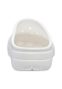 Bottine blanche à enfiler avec un dos arrondi, texture plastique lisse, trous de ventilation et semelle texturée pour une meilleure adhérence.