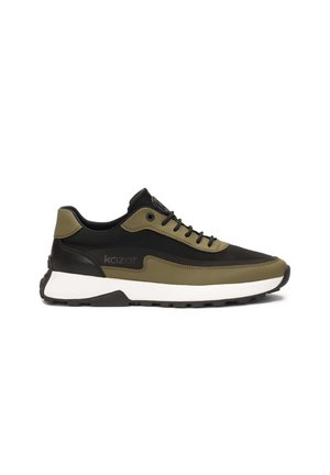 Zapatillas con un diseño en verde oliva y negro, fabricadas con materiales sintéticos. Cuentan con una suela blanca, cordones planos y un acento del logo en el lateral.