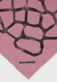 Ροζ μπανανά με μαύρο αφηρημένο σχέδιο πλέγματος, κατασκευασμένη από μαλακό ύφασμα, με την επιγραφή "SALOMON" σε έντονο μαύρο στο κάτω άκρο.