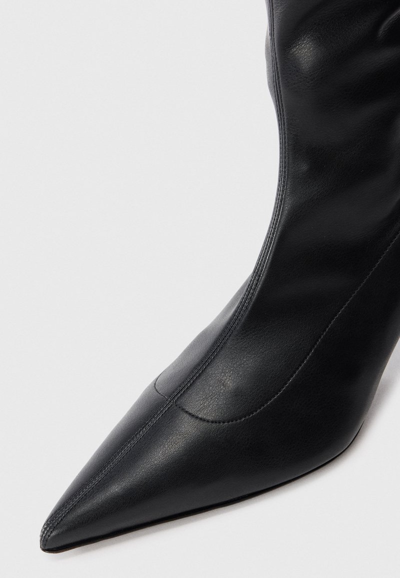 Schwarze Leder-Ankle-Boots mit spitzem Zeh, glatter Textur und minimalen Nähten. Elegantes Design mit passgenauer Optik.