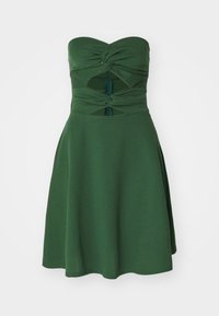 Bezramienkov dress v zelenej farbe s nariadeným živôtikom, výrezom v oblasti pásu, priliehavým strihom, rozšírenou sukňou a jemnou textúrou látky.