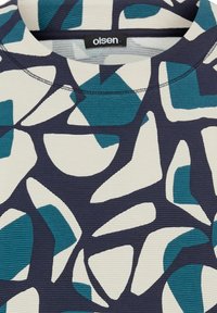 Maglione a motivi multicolori con forme curve in verde acqua e blu navy su sfondo crema. Tessuto a coste e scollatura a girocollo.