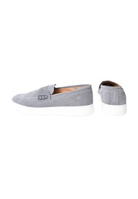 Scarpe slip-on in suede grigio con suole in gomma bianca, dotate di un design cucito e di minime accentuazioni in metallo sui lati.