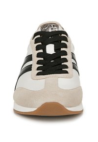 Sneaker bianchi con strisce nere, materiali scamosciato e tela, punta rotonda, lacci neri e suola in gomma marrone. Logo argentato sulla linguetta.