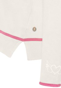 Witte gebreide trui met roze accenten, geribbelde textuur, zijsplit en een decoratieve grijze knop met een roze kattenontwerp.