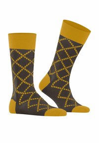 Brązowe skarpetki z żółtymi akcentami, z geometrycznym wzorem w przekątnej. Teksturowane ściągacze i wzmocnione fragmenty na palcach dopełniają całość.