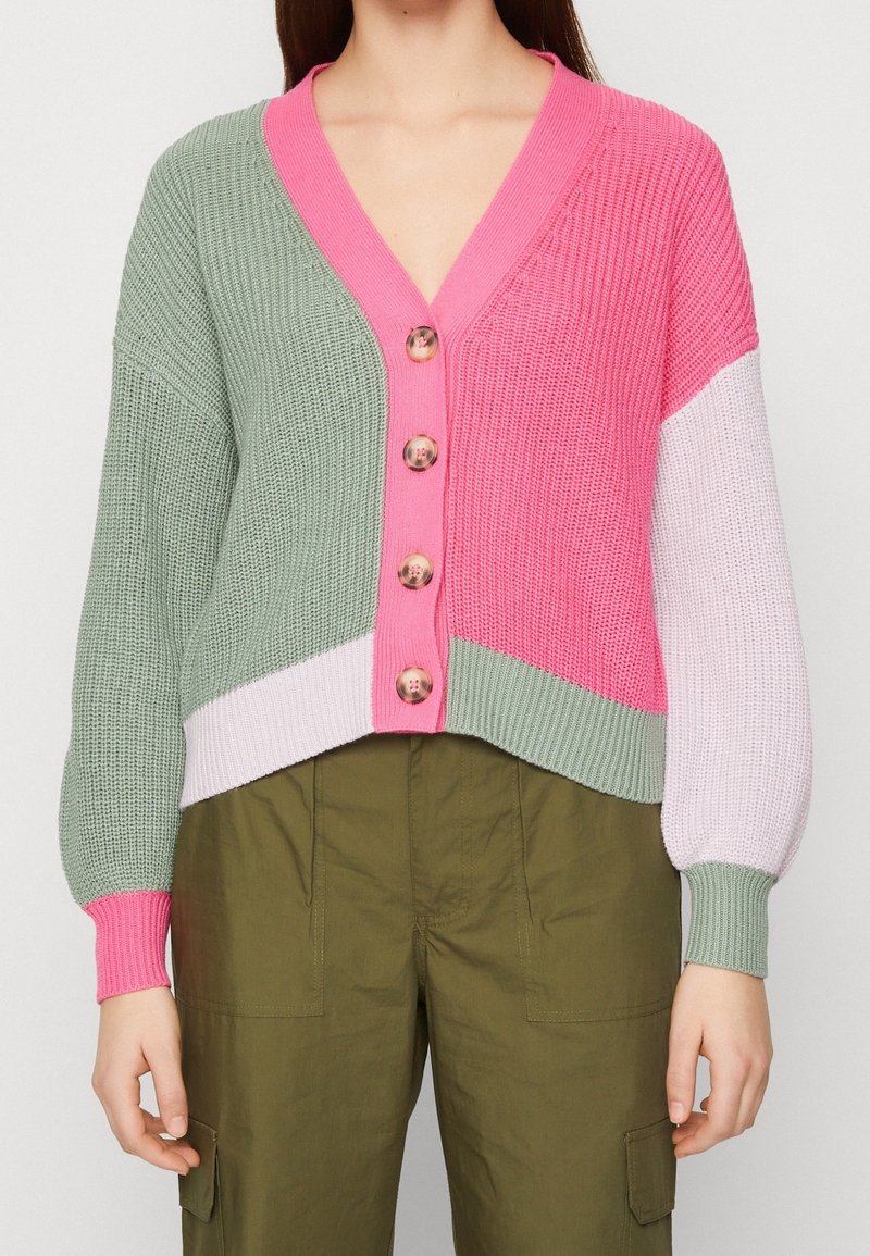 Cardigan en tricot avec des blocs de couleurs vert, rose et lavande, design en v et boutons ronds. Tissu texturé avec des poignets côtelés.