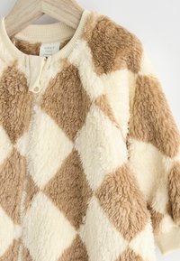 Fleece jakna na zip s dijamantnim uzorkom u bež i krem boji, s teksturiranim materijalom i rebrastim okovratnikom.