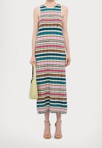 Robes sans manches à rayures avec des rayures horizontales multicolores, tissu texturé, longueur genoux, et dentelle en bas. Accompagnée d'un sac à main léger.