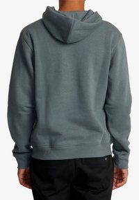 Sudadera con capucha hecha de suave tejido azul grisáceo. Presenta un ajuste holgado, puños y dobladillo acanalados. Textura suave con un diseño minimalista.