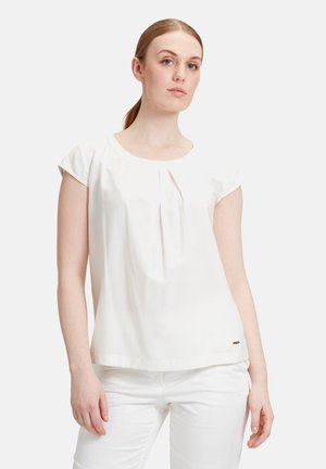 Weiße Bluse mit kurzen Ärmeln und Rundhalsausschnitt, die subtile Fältchen und einen abgerundeten Saum aufweist. Weicher Stoff mit einer leichten, glatten Textur.