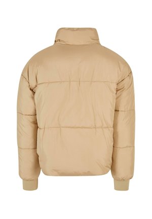 Beige puffer-takki korkealla kauluksella, tikattu muotoilu ja elastiset hihansuut. Sujuva pinta ja hieman yli-iso muoto.