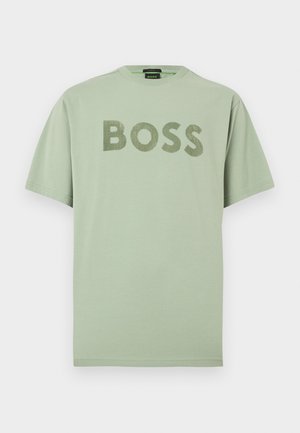 Camiseta de algodón verde claro con un destacado logo "BOSS" en un estampado texturizado de color verde oscuro. Cuello redondo clásico y mangas cortas.