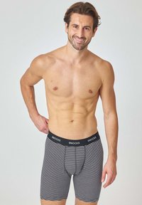 Boxer shorts a righe bianche e nere con elastico in vita. Il tessuto sembra morbido, con un design aderente e una lunghezza a metà coscia.