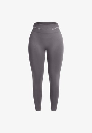 Leggings gris sin costuras con una cintura alta que presenta texto de marca en blanco. Hechos de una tela elástica y suave para mayor comodidad.