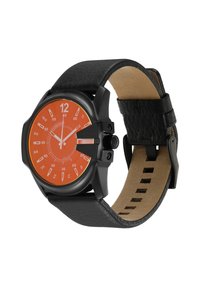 Montre noire avec un cadran octogonal, un cadran orange, des index horaires blancs et un bracelet en cuir noir texturé avec une doublure beige.