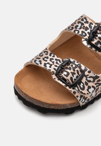 Lepardmønstret slidesandal med metallisk finish, to justerbare sorte spænder, korkindlæg og struktureret sort gummisåle.