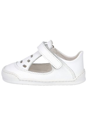 Zapato para niño pequeño de cuero blanco con tira de velcro, parte superior perforada y suela de goma flexible.