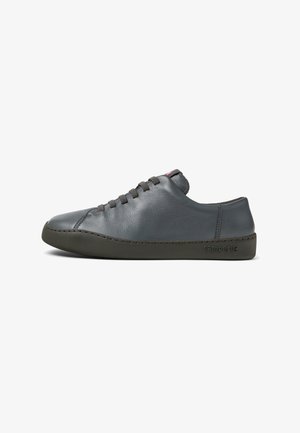 Gray leather sneaker with minimalistic design, rubber sole, rounded toe, and lace-up front. Features tonal stitching and a subtle logo.