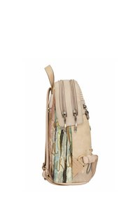 Sac à dos beige avec compartiments à double fermeture éclair, bretelles réglables et motif de texte abstrait multicolore sur le côté.