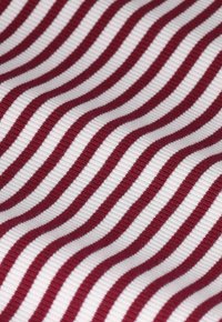 Baumwollstoff mit abwechselnd roten und weißen wellenförmigen Streifen sowie einer gerippten Textur, die ein dynamisches visuelles Muster schafft.