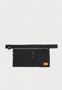 Svart lerretsverktøygj belt med metallglidelås, flere lommer og knappelukkinger, med en liten oransje merkeetikett.