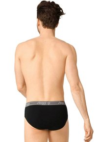 Culotte en coton noir avec taille élastique grise, arborant le logo "sloggi", design simple sans motifs et texture lisse.