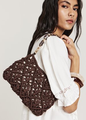 Sac en macramé brun avec un tissage à motifs, en forme de triangle, et une poignée en chaîne dorée. Surface texturée avec des détails complexes.