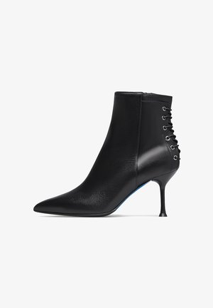 Stivale alla caviglia in pelle nera con punta affusolata, design aderente e dettaglio allacciato sul retro. Presenta un sottile tacco a stiletto.