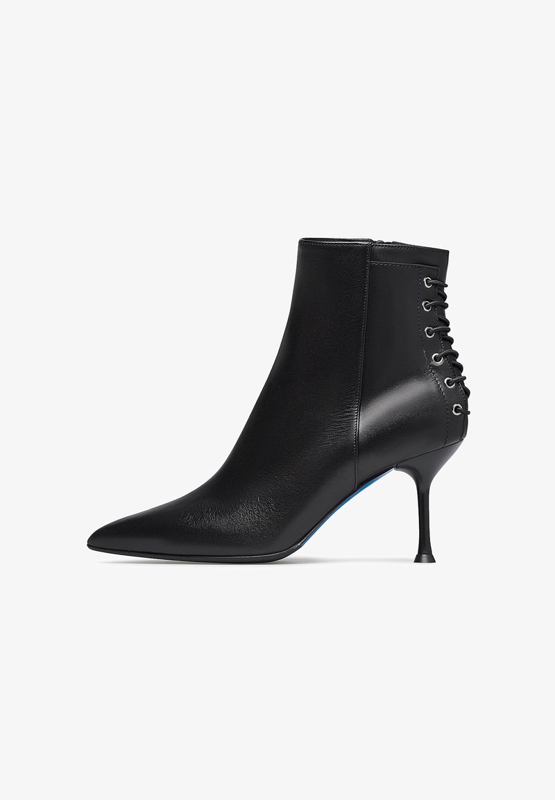 Stivale alla caviglia in pelle nera con punta affusolata, design aderente e dettaglio allacciato sul retro. Presenta un sottile tacco a stiletto.