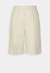 Lněné šortky ve světle béžové barvě s uvolněným střihem. Mají plochý pas a boční sklady pro zvýšení pohodlí. Čistý design bez vzorů.