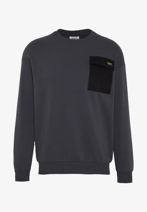 Donkergrijze crewneck trui met lange mouwen en een zwart kleppenzakje op de linkerborst met groene tekst "YRT."