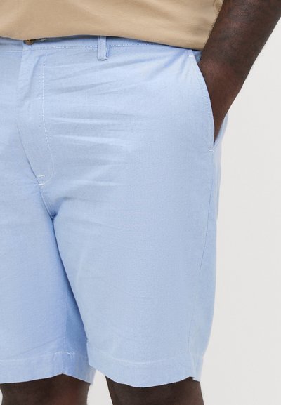 Shorts bleu clair en tissu doux et texturé avec poches latérales et ourlet soigné. Présente une coupe plate à l'avant et des passants de ceinture.