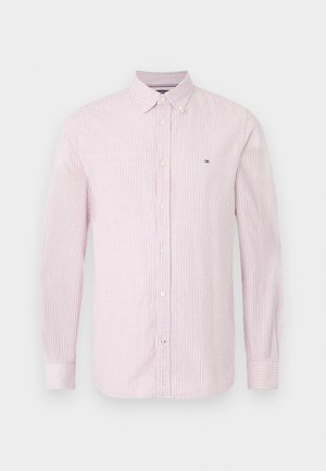 Hosszú ujjú gombos ing piros és fehér függőleges csíkokkal, klasszikus gallérral és kis logóval a bal mellrészen. Pamut anyag.