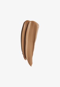 Romige foundation swatch in een warme tan tint, met een gladde textuur en glanzende afwerking, aangebracht in twee overlappende strepen op een witte achtergrond.