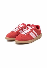 Zapatillas de ante rojas con acentos rosas, que presentan una puntera redondeada, cordones blancos y suela de goma. Se observan franjas laterales y detalles del logo.