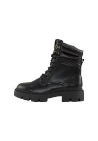 Botas negras con cordones, con un acabado de cuero brillante, cuello acolchado y suela de goma gruesa. Presentan ojales de metal y una marca en el lado.