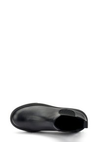 Botín de cuero negro hasta el tobillo con punta redondeada, acentos laterales elásticos y una textura suave. Incluye una suela de goma de perfil bajo.