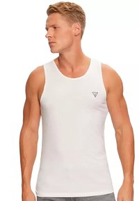 Witte tanktop van gladde stof, met een ronde halslijn en een klein driehoekig logo op de linkerborst. De pasvorm is atletisch.