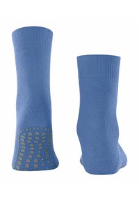 Jasnoniebieskie skarpetki z żebrowanymi mankietami i teksturowanymi gumowymi gripami na podeszwach, zaprojektowane w celu zapewnienia lepszej przyczepności i stabilności.