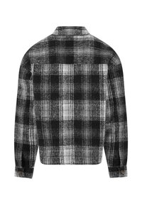 Svart og hvit rutete flanellskjorte, med lange ermer, krage med knapper og baklomme. Myk tekstur, firkantet fasong.