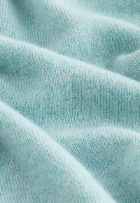 Lichtblauwe gebreide stof met een zachte textuur, met een subtiel gemêleerd patroon en verhoogde breipatronen door het hele oppervlak.