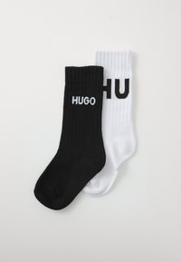Fekete-fehér bordázott zoknik, az "HUGO" sz�ó kontrasztos színekben, fekete betűkkel a fehér zoknin és fehér betűkkel a fekete zoknin.