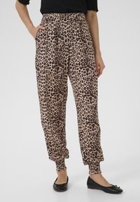 Pantaloni con stampa a macchie di leopardo, con vita elastica, polsini arricciati e tasche laterali. Tessuto morbido e leggero in beige e marrone scuro.