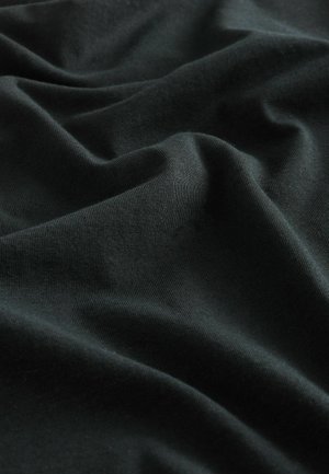Material din bumbac negru cu textură fină, având pliuri moi și cute care creează adâncime și un aspect bogat, întunecat.