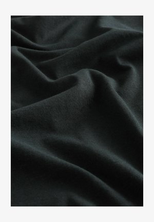 Mustast puuvillast kangas, millel on sile tekstuur ja pehmed kortsus voldid, mis loovad sügavust ja rikkaliku tumeda väljanägemise.