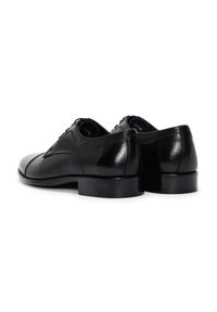 Chaussures habillées en cuir noir avec une finition brillante, bout arrondi, petit talon, et lacets. Texture lisse avec des accents de coutures discrètes.