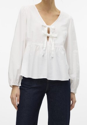 Blusa bianca in cotone con scollo a V, dettaglio con fiocco sul collo e maniche lunghe a sbuffo. Tessuto strutturato con vestibilità comoda.