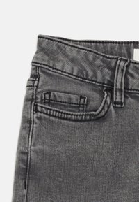 Gray denim jeans with a sleek texture, featuring a small front pocket and visible stitching details along the waist and seams.