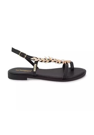 Black flat sandal with gold leaf embellishments, ankle strap, and toe loop, labeled "Les Tropeziennes."